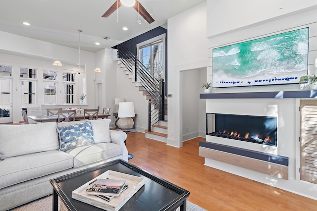 living room featuring ceiling fan and hardwood / wood-style floors