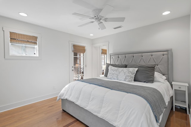 bedroom with multiple windows, hardwood / wood-style floors, and ceiling fan