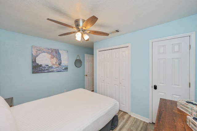 bedroom with wood-type flooring, a closet, and ceiling fan