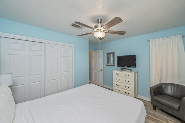 bedroom with ceiling fan, a closet, and light wood-type flooring