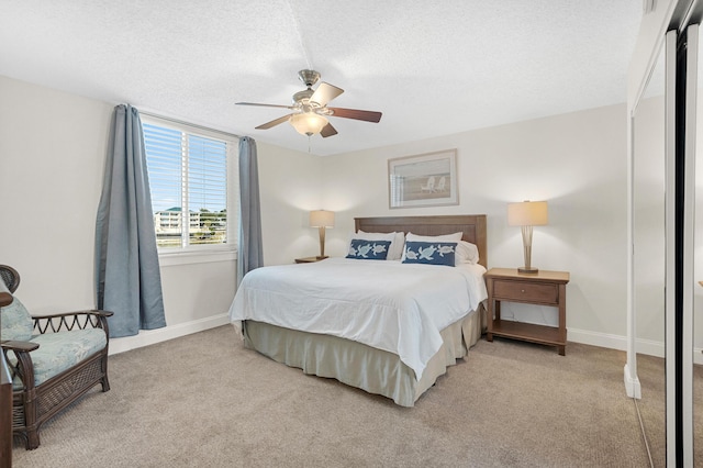 carpeted bedroom with a textured ceiling and ceiling fan