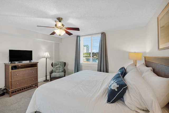 bedroom featuring a textured ceiling, ceiling fan, and carpet