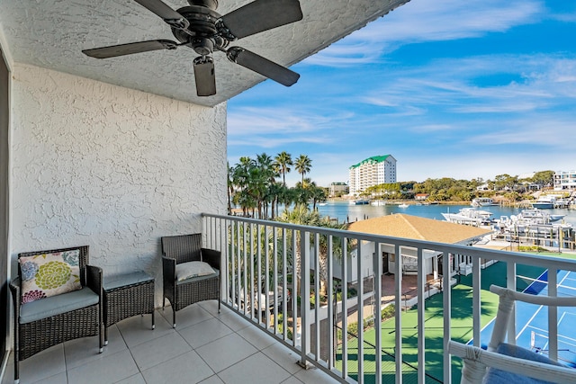 balcony featuring ceiling fan and a water view