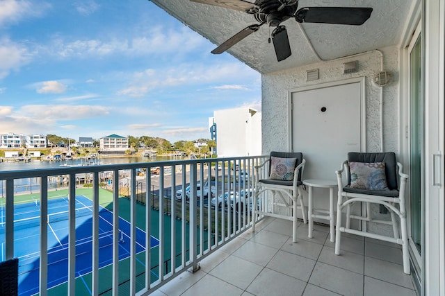 balcony with a water view and ceiling fan