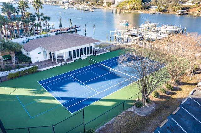 view of tennis court with a water view