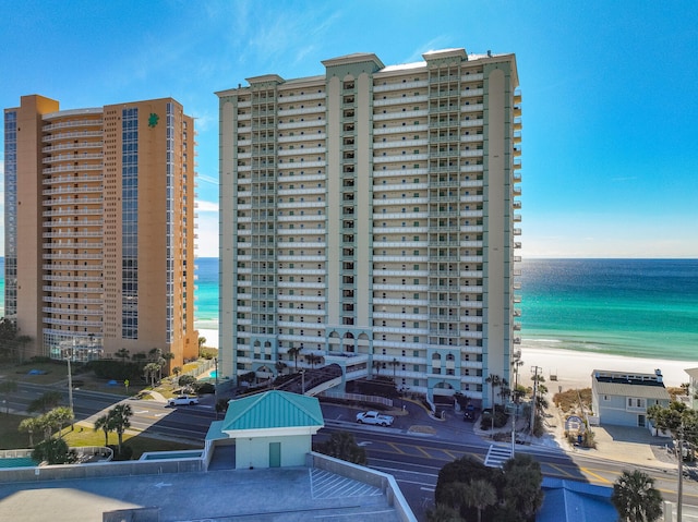 view of property with a water view and a view of the beach