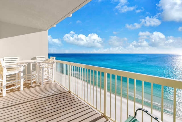 balcony featuring a beach view and a water view