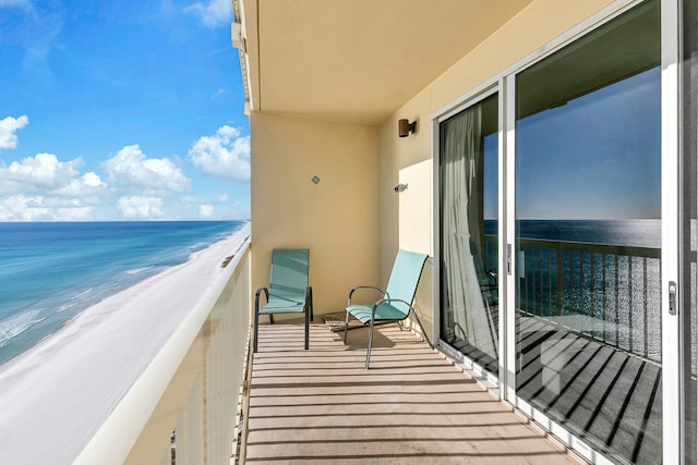 balcony featuring a water view and a view of the beach