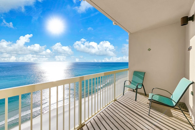 balcony featuring a water view and a view of the beach