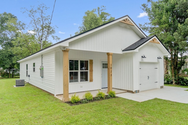 view of front facade with a garage, a front yard, and cooling unit