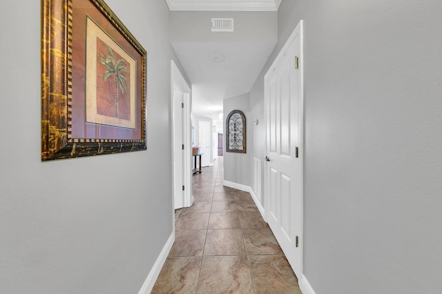 hallway featuring crown molding and light tile patterned floors