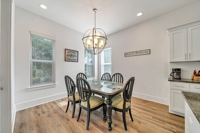 dining room with light hardwood / wood-style floors and an inviting chandelier