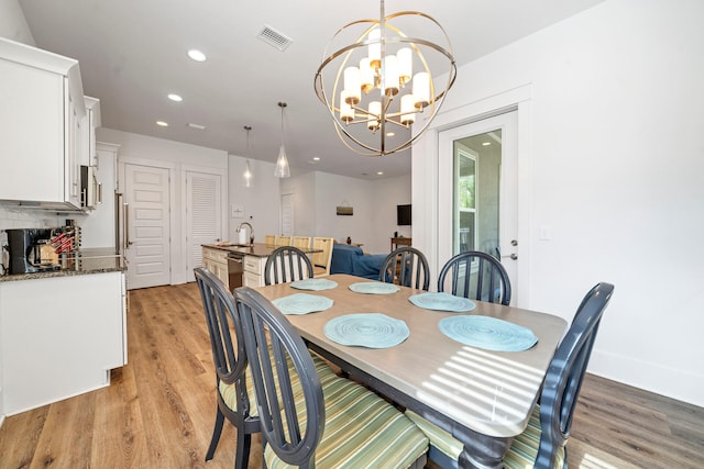 dining room featuring light hardwood / wood-style flooring and a notable chandelier