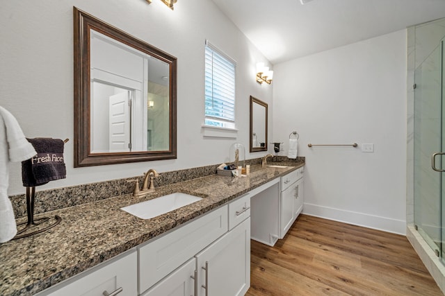 bathroom featuring wood-type flooring, a shower with door, and vanity