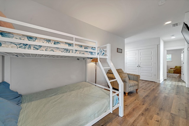 bedroom with wood-type flooring and a closet