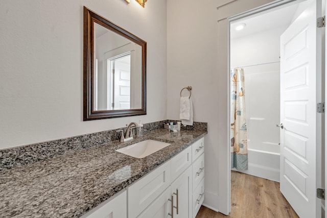 bathroom featuring hardwood / wood-style flooring, vanity, and shower / bath combination with curtain