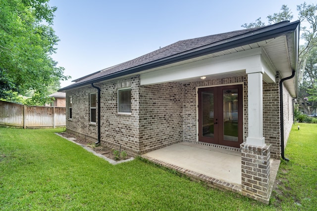 back of property featuring a patio, french doors, and a yard