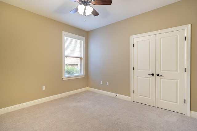 unfurnished bedroom featuring light carpet, a closet, and ceiling fan