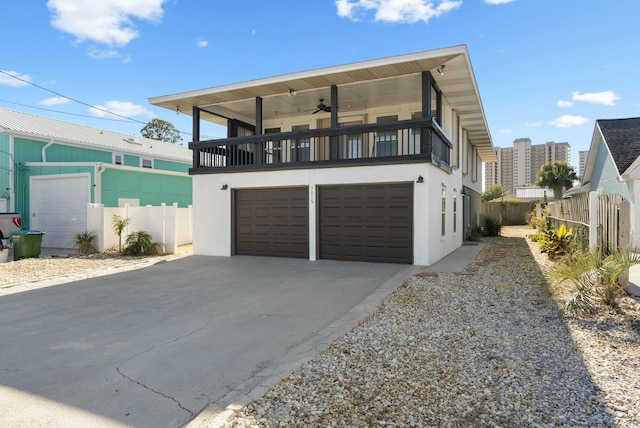 view of front facade featuring ceiling fan, a balcony, a garage, and a sunroom