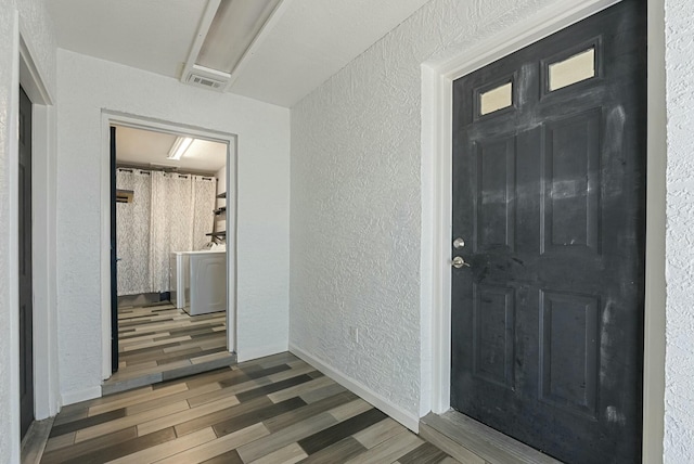 entryway featuring dark hardwood / wood-style flooring and washer / dryer