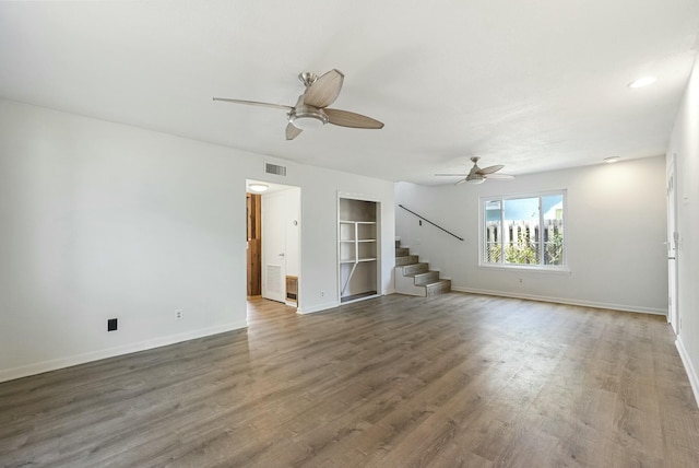 unfurnished living room featuring ceiling fan and dark hardwood / wood-style flooring