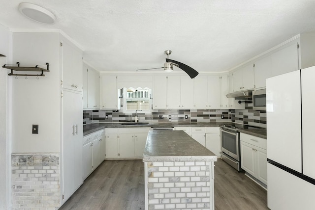 kitchen with a center island, appliances with stainless steel finishes, white cabinetry, sink, and ceiling fan