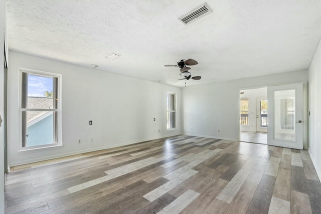 unfurnished room featuring ceiling fan, hardwood / wood-style floors, and a textured ceiling