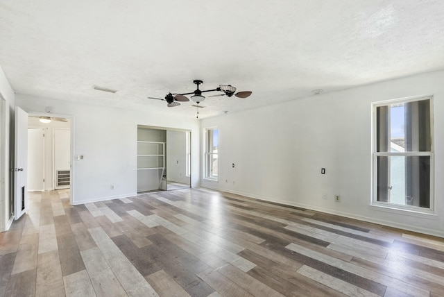 empty room featuring hardwood / wood-style floors, a textured ceiling, and ceiling fan