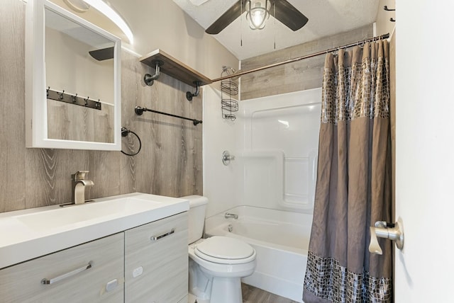 full bathroom with a textured ceiling, wood-type flooring, vanity, shower / bath combination with curtain, and toilet