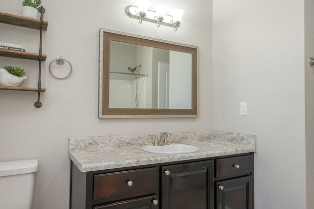 bathroom featuring vanity, toilet, and a shower