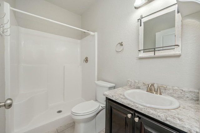 bathroom featuring a shower, vanity, tile patterned floors, and toilet