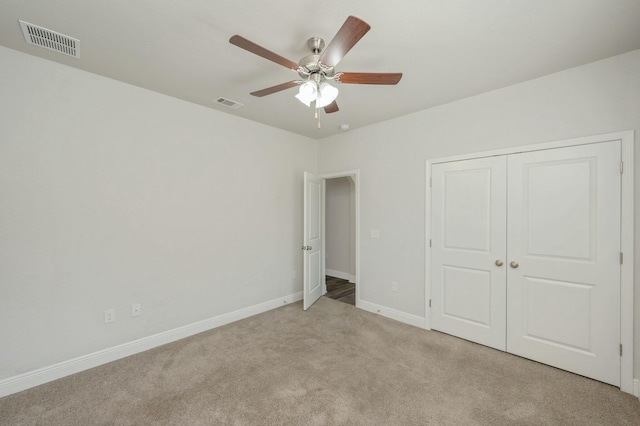 unfurnished bedroom with light carpet, a closet, and ceiling fan