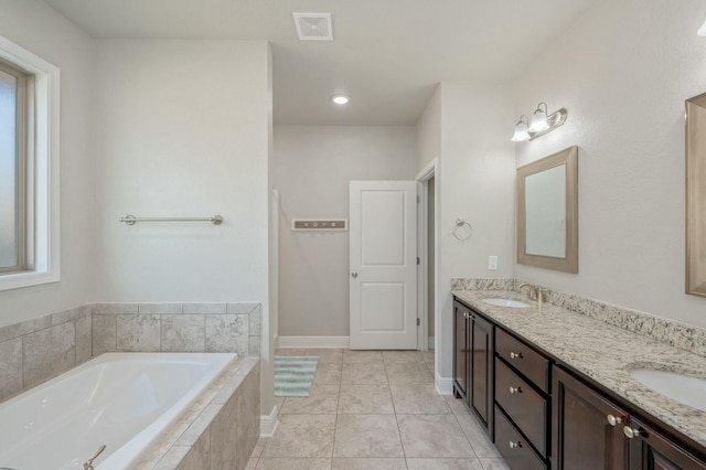 bathroom with vanity, a relaxing tiled tub, and tile patterned floors