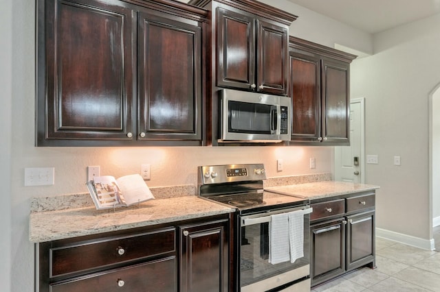 kitchen with light tile patterned floors, dark brown cabinets, and appliances with stainless steel finishes