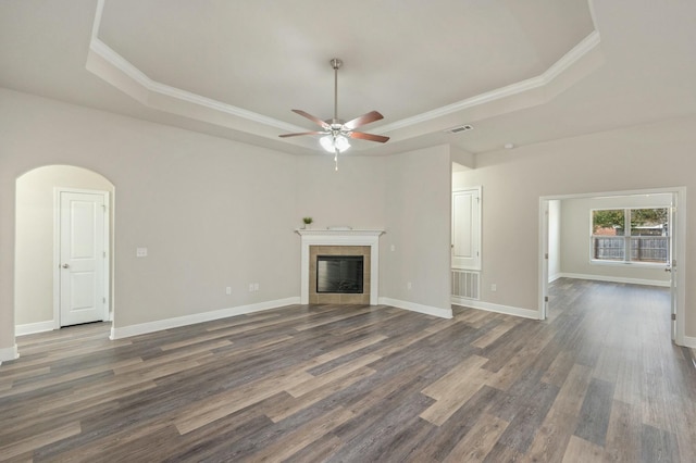 unfurnished living room with a raised ceiling, dark hardwood / wood-style floors, and a fireplace