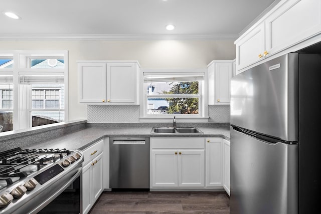 kitchen featuring dark wood-type flooring, sink, white cabinetry, ornamental molding, and appliances with stainless steel finishes