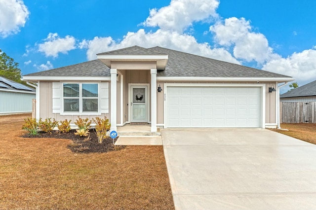 ranch-style home with an attached garage, fence, concrete driveway, roof with shingles, and board and batten siding