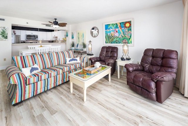 living room featuring ceiling fan and light wood-type flooring