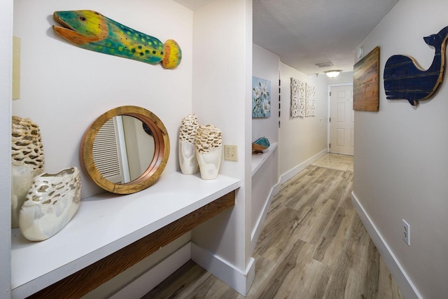 hallway with wood-type flooring and a textured ceiling