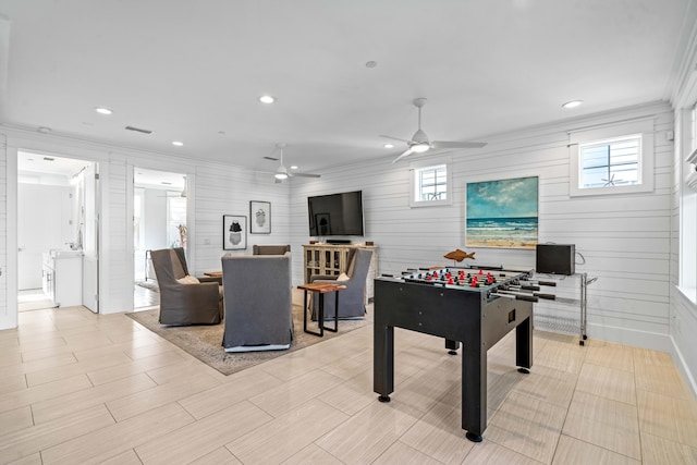 game room with ceiling fan and ornamental molding