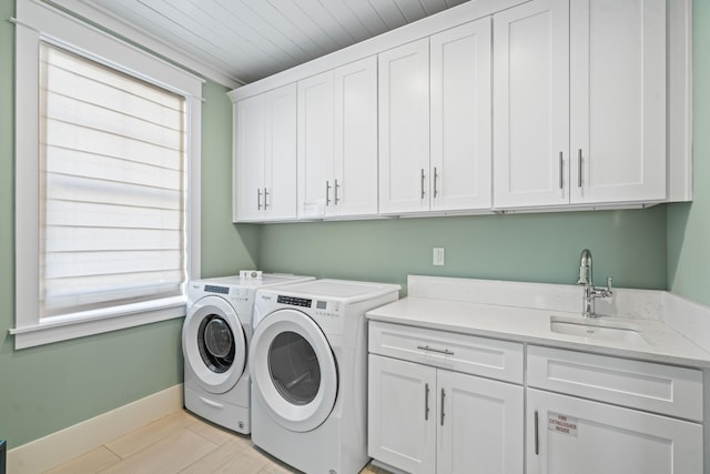 laundry room with sink, cabinets, washer and clothes dryer, and light hardwood / wood-style floors