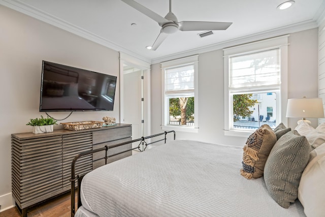 bedroom with hardwood / wood-style flooring, ceiling fan, and ornamental molding