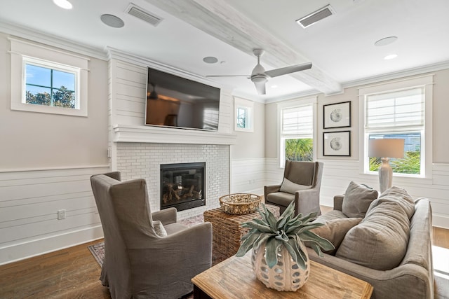 living room with ornamental molding, a brick fireplace, beam ceiling, and dark hardwood / wood-style flooring