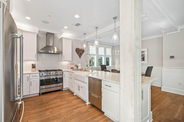 kitchen with white cabinetry, wall chimney range hood, and stainless steel appliances