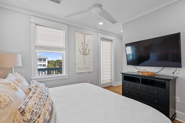 bedroom with light wood-type flooring, ceiling fan, and crown molding