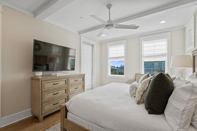 bedroom featuring hardwood / wood-style floors, beam ceiling, ceiling fan, and ornamental molding