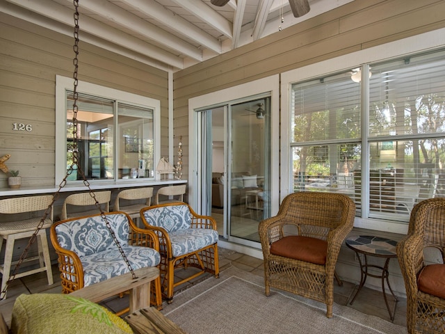 sunroom featuring beamed ceiling and ceiling fan