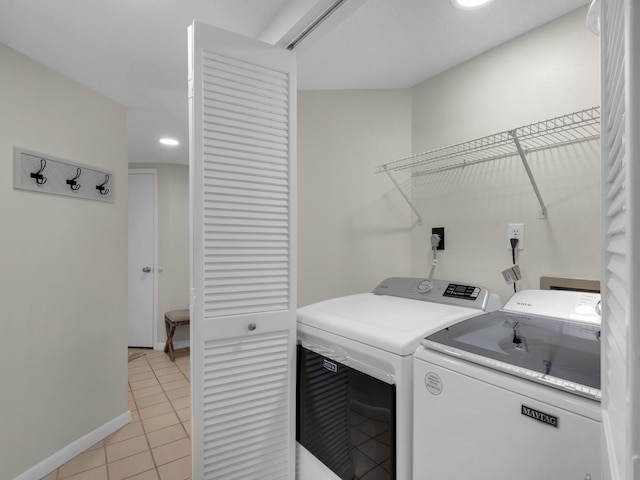 washroom featuring washing machine and clothes dryer and light tile patterned floors