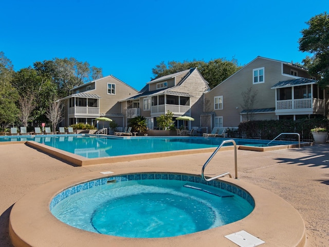 view of pool with a hot tub