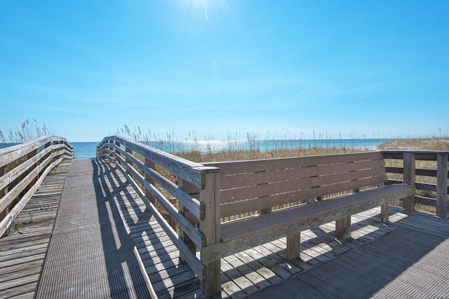 view of property's community with a water view and a beach view